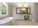 Luxury bathroom featuring a soaking tub, granite vanity, and a large mirror at 385 Windy Pines Trl, Roswell, GA 30075