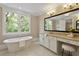 Bright bathroom with soaking tub, large window, and vanity area at 385 Windy Pines Trl, Roswell, GA 30075