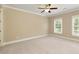 Spacious, carpeted bedroom with crown molding, ceiling fan, and windows, allowing natural light at 385 Windy Pines Trl, Roswell, GA 30075