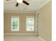 Large, carpeted bedroom has a ceiling fan and two windows with blinds for natural light and privacy at 385 Windy Pines Trl, Roswell, GA 30075