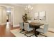 Modern dining room features elegant chandelier, stylish art, and seating for six guests at 385 Windy Pines Trl, Roswell, GA 30075