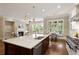 Open concept kitchen with a large center island and adjacent living space with fireplace at 385 Windy Pines Trl, Roswell, GA 30075