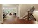 Open-concept living area with hardwood floors, a staircase, and seamlessly connects to dining and kitchen spaces at 385 Windy Pines Trl, Roswell, GA 30075