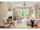 Cozy living room with fireplace, plush seating, and bright natural light from large windows at 385 Windy Pines Trl, Roswell, GA 30075