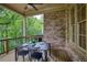 Covered porch with outdoor dining set for four, ceiling fan, and brick exterior at 385 Windy Pines Trl, Roswell, GA 30075