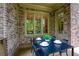 Covered porch with outdoor dining set for four and brick exterior at 385 Windy Pines Trl, Roswell, GA 30075