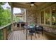Covered porch with outdoor dining set for four, ceiling fan, and brick exterior at 385 Windy Pines Trl, Roswell, GA 30075