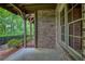An outdoor patio showcasing the home's brick facade, large windows, and concrete flooring at 385 Windy Pines Trl, Roswell, GA 30075