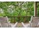 Peaceful view from a porch with comfortable rocking chairs and wood flooring at 385 Windy Pines Trl, Roswell, GA 30075