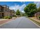 Exterior street view of luxury townhomes showcasing garages, landscaping, and manicured lawns at 385 Windy Pines Trl, Roswell, GA 30075