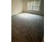 A simple empty bedroom has gray carpet and a window with blinds at 6449 Pinebark Way, Morrow, GA 30260