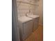 Bright laundry room with standard-size white washer and dryer, and wire shelving above at 6449 Pinebark Way, Morrow, GA 30260