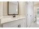 Bathroom showcasing marble countertops, tiled floors, a white vanity and a black framed mirror at 1330 Adams Sw Dr, Atlanta, GA 30311