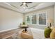 Bedroom featuring hardwood floors, a modern white settee, and natural light from multiple windows at 1330 Adams Sw Dr, Atlanta, GA 30311