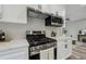 Modern kitchen features stainless steel appliances, sleek white cabinets, and elegant quartz countertops with herringbone backsplash at 1330 Adams Sw Dr, Atlanta, GA 30311