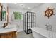 Nautical bathroom featuring a freestanding tub, black framed shower, ship wheel, and modern fixtures at 2705 Osborne Ne Rd, Brookhaven, GA 30319