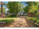 Gravel drive leading to a charming two-story home with lush greenery and mature trees at 2705 Osborne Ne Rd, Brookhaven, GA 30319