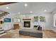 Comfortable living room with a cozy fireplace, hardwood floors, and abundant natural light from the large windows at 2705 Osborne Ne Rd, Brookhaven, GA 30319