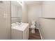 Neutral bathroom features a white single sink vanity with laminate floors and standard toilet at 6082 Raintree Bnd, Lithonia, GA 30058