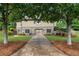 Back exterior of home featuring stone accents, manicured landscaping, and a private yard at 6263 Fernstone Nw Trl, Acworth, GA 30101