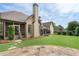 Beautifully landscaped backyard featuring a stone patio, well-manicured lawn, and mature trees at 6263 Fernstone Nw Trl, Acworth, GA 30101