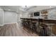 Basement wet bar with a brick backsplash, wood accents, multiple bar stools and a tv at 6263 Fernstone Nw Trl, Acworth, GA 30101