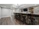 Basement bar area with wooden facade, shelving, TV, and modern barstools at 6263 Fernstone Nw Trl, Acworth, GA 30101