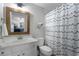 Bathroom featuring a white vanity, framed mirror, and a modern shower curtain at 6263 Fernstone Nw Trl, Acworth, GA 30101