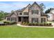 Charming stone and tan two-story home with manicured lawn and mature landscaping at 6263 Fernstone Nw Trl, Acworth, GA 30101