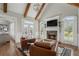 Cozy living room featuring a stone fireplace, vaulted ceiling, and lots of natural light at 6263 Fernstone Nw Trl, Acworth, GA 30101