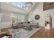 Bright living room with vaulted ceiling, large windows, hardwood floors, and comfortable seating with an elegant chandelier at 6263 Fernstone Nw Trl, Acworth, GA 30101