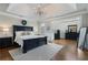 Serene main bedroom with tray ceiling, dark wood furniture, and large windows at 6263 Fernstone Nw Trl, Acworth, GA 30101