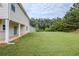 Large, grassy backyard with covered patio, surrounded by trees, perfect for outdoor activities at 8826 Lakecrest Way, Union City, GA 30291