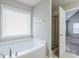 Bright bathroom featuring a soaking tub and a glass-enclosed shower in a neutral color palette at 8826 Lakecrest Way, Union City, GA 30291