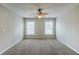 Light-filled bedroom features a ceiling fan and two windows, offering a comfortable and airy space at 8826 Lakecrest Way, Union City, GA 30291