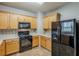 Practical kitchen with wooden cabinets, black appliances, and plenty of counter space for meal preparation at 8826 Lakecrest Way, Union City, GA 30291