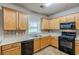 Functional kitchen with wooden cabinetry, black appliances, tile backsplash, and a bright window at 8826 Lakecrest Way, Union City, GA 30291
