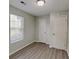 Bedroom featuring new laminate flooring, a large window, and a double door closet with white doors at 119 Michelle Dr, Mcdonough, GA 30252