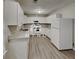 Well-lit kitchen with white cabinets, modern appliances, granite countertops and updated floors at 119 Michelle Dr, Mcdonough, GA 30252
