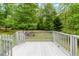 View of home's deck surrounded by lush trees and grassy yard at 236 Fairview Dr, Dallas, GA 30157