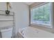 Bathroom featuring modern tub, faucet, sink, toilet, and large window at 236 Fairview Dr, Dallas, GA 30157
