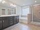Bathroom with double vanity, soaking tub, tiled floors, glass enclosed shower, and neutral color palette at 3305 Morgan Rd, Buford, GA 30519