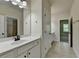 Well-lit bathroom featuring white vanity, large mirror, and tile flooring at 4610 Point Rock Dr, Buford, GA 30519