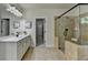 Bathroom featuring glass-enclosed shower with neutral stone tile and bright vanity at 4610 Point Rock Dr, Buford, GA 30519