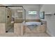 Spacious bathroom features a walk-in shower with glass door, a jacuzzi tub, and a neutral color palette at 4610 Point Rock Dr, Buford, GA 30519