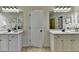 Primary bathroom featuring double sink vanity, large mirrors, and neutral tile flooring at 4610 Point Rock Dr, Buford, GA 30519
