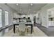 Bright dining room with modern light fixtures, a black table, white trim, and a view of the kitchen at 4610 Point Rock Dr, Buford, GA 30519