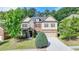Inviting two-story home featuring a well-manicured lawn and a blend of brick, stone, and siding accents at 4610 Point Rock Dr, Buford, GA 30519