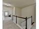 Carpeted upstairs hallway features a white railing and a view into a bedroom through an open doorway at 4610 Point Rock Dr, Buford, GA 30519