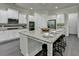 Well-lit kitchen features white cabinets, granite countertops, stainless steel appliances, and large center island at 4610 Point Rock Dr, Buford, GA 30519